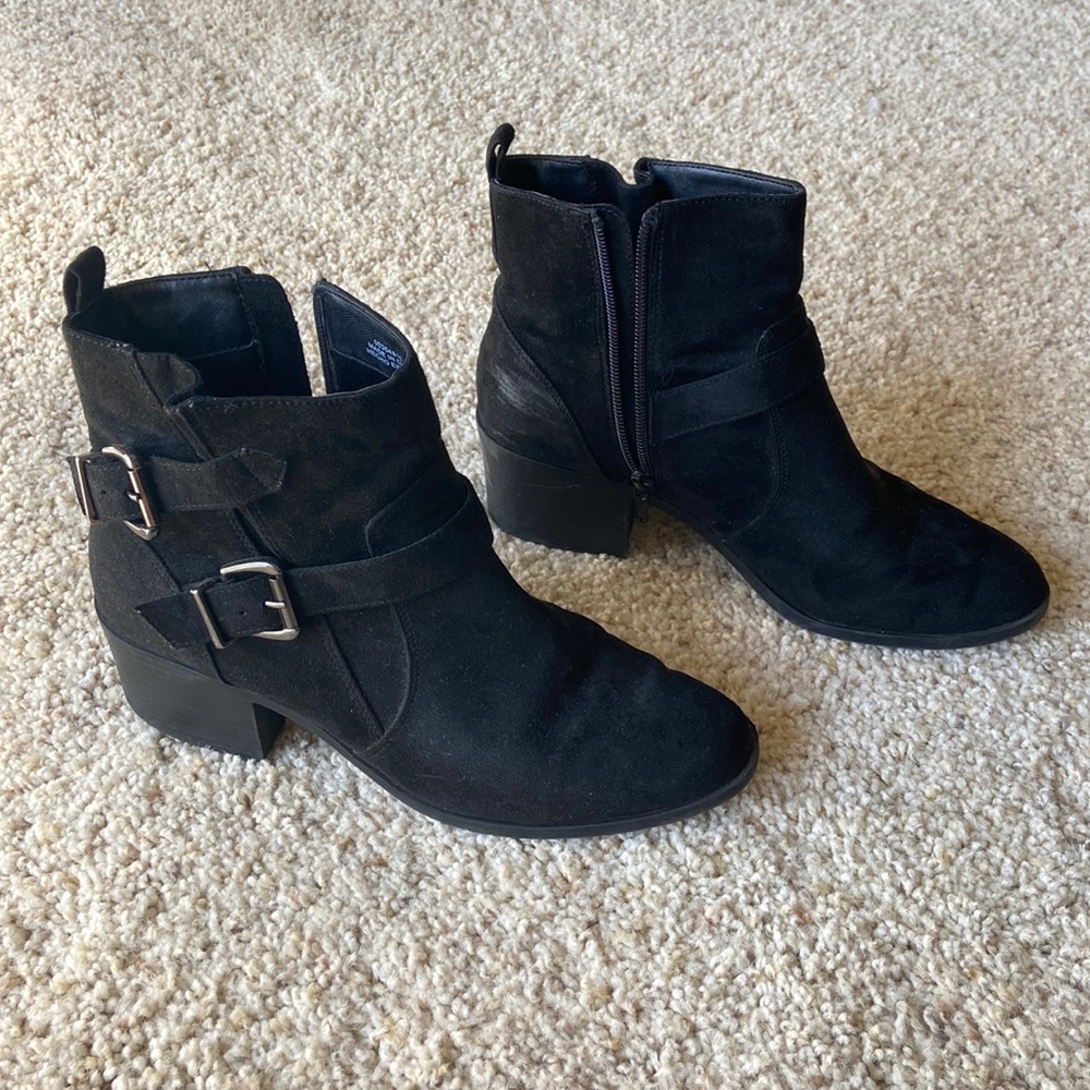 Lighting worn black suede ankle boots